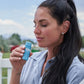 Woman holding a blue container outdoors with a blurred background