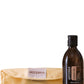 A bottle of doTERRA Castor Oil next to a folded beige doTERRA microfiber cloth on a plain white background.
