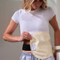 A woman wearing a white t-shirt and striped pajama pants demonstrates a beige maternity support belt with a black undergarment, showing how the support belt fits around her midsection. doTERRA Castor Oil Wrap Pack