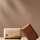 Bar of soap with packaging on a neutral background